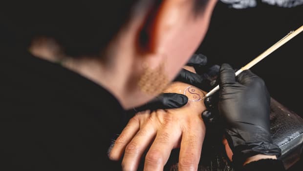 person doing hand poke tattoo.
