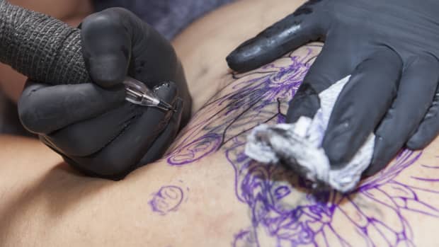 tattoo artist beginning to tattoo client