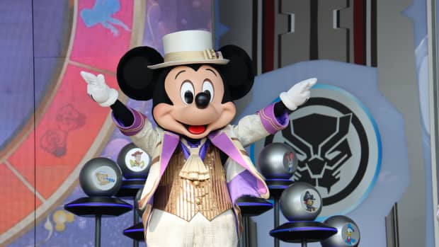Mickey mouse with a hat and suit on.