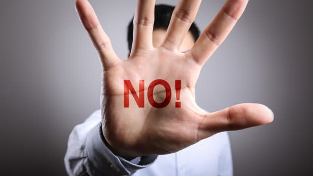 person with the word "no on the palm of their hand