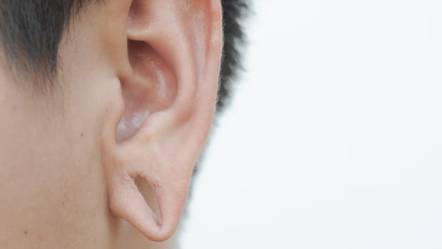 a person with a stretched ear piercing.