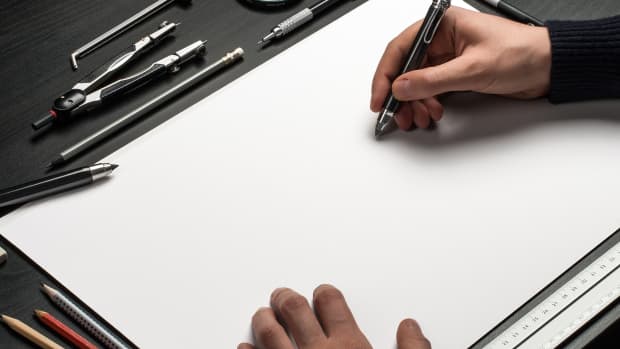 A person using pen to sketch a drawing.