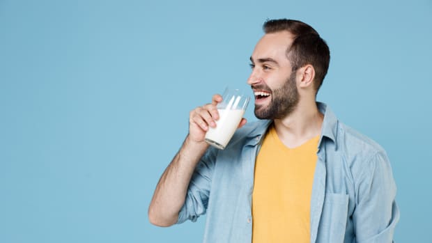 a man happily drinks milk.