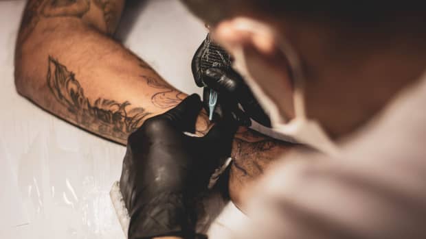 tattoo artist tattooing someone's wrist.