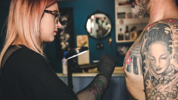 tattoo artist marks on client.